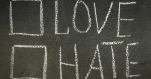 Chalkboard displaying the message 'LOVE' over 'HATE' to emphasize choosing love over hate.